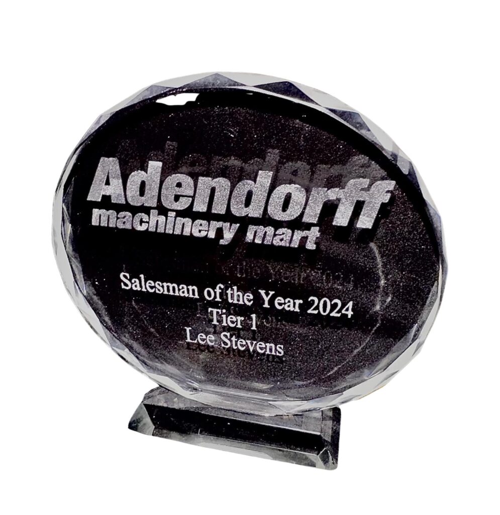 Close-up of a laser-engraved glass trophy showing precise text and logo details